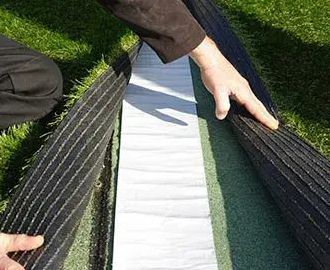 Jonction entre deux lés d'herbe artificielle