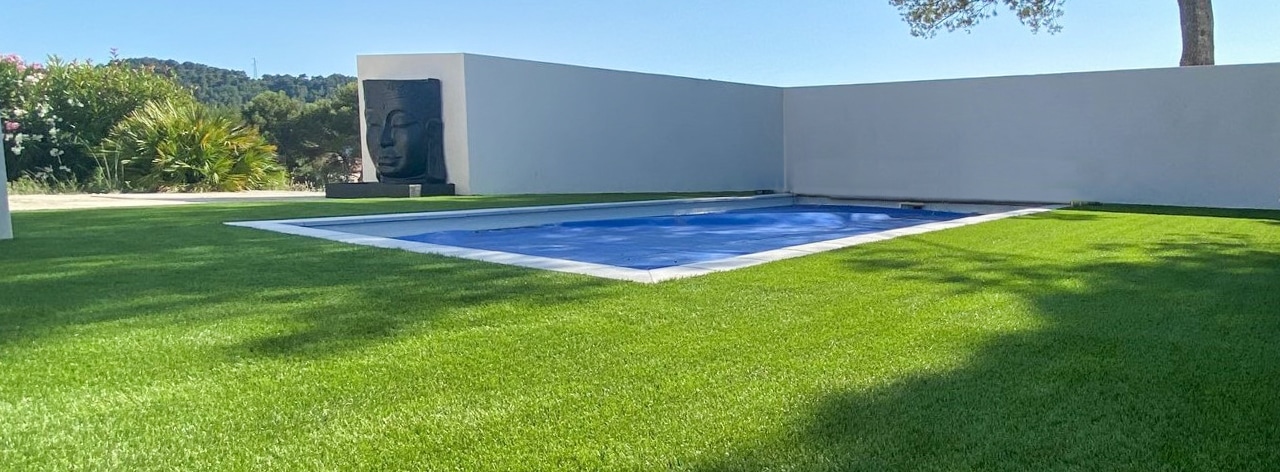 Dalle béton autour d'une piscine recouvert en pelouse artificielle
