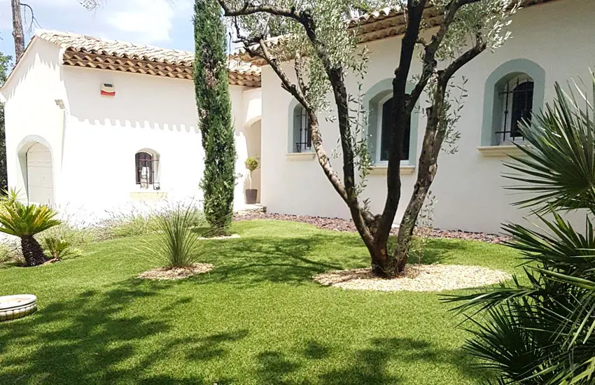 Extérieur de maison provençale blanche avec gazon synthétique